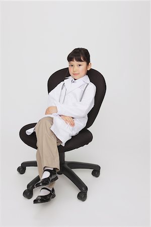 preteen girl with doctor - Girl Dressed Up As Doctor Sitting on Chair Stock Photo - Rights-Managed, Code: 859-03806116