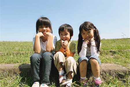 Children Sitting In Grassy Field Stock Photo - Rights-Managed, Code: 859-03806210