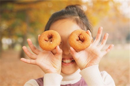 Preteen Girl Looking Trough Hole In Bagel Stock Photo - Rights-Managed, Code: 859-03839425