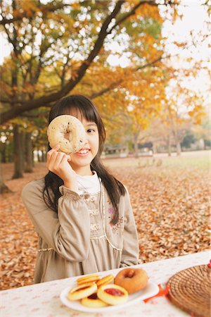 Preteen Girl Looking Trough Hole In Bagel Foto de stock - Con derechos protegidos, Código: 859-03839423