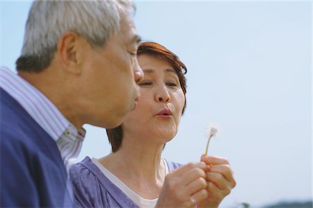 senior activities - Middle-Aged Couple Blowing Dandelion Flower Stock Photo - Rights-Managed, Code: 859-03840306