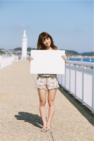 Young Woman By Seafront Holding Whiteboard Stock Photo - Rights-Managed, Code: 859-03840415