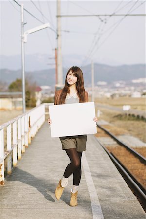 simsearch:859-03860700,k - Pretty Young Woman On Platform Holding Whiteboard Foto de stock - Con derechos protegidos, Código: 859-03860704