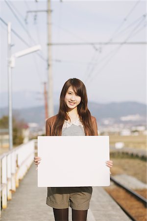 simsearch:859-03860700,k - Pretty Young Woman On Platform Holding Whiteboard Foto de stock - Con derechos protegidos, Código: 859-03860705