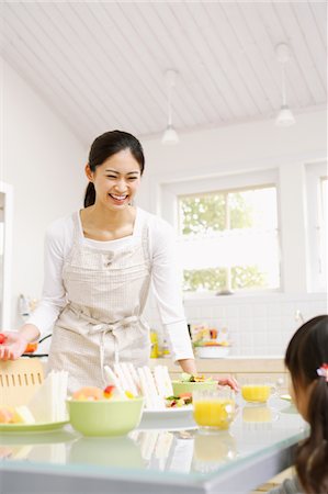 family indoors house parent ethnic not beach not park - Smiling Woman Serving Food To Her Daughter Stock Photo - Rights-Managed, Code: 859-03884837