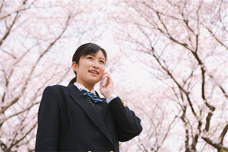 High School Girl Listening To Phone Under Blooming Tree Stock Photo - Rights-Managed, Code: 859-03884977