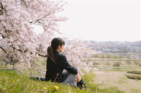 simsearch:400-04416781,k - Lycéenne, assis sous l'arbre de la cerise fleur Photographie de stock - Rights-Managed, Code: 859-03884991