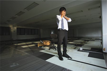Businessman Standing At Deserted Office Head On Hands Stock Photo - Rights-Managed, Code: 859-03983039