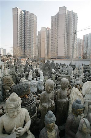 A contrast of old and new: modern skyscrapers beside old Buddhist statues at Panjiayuan flea market,Beijing's largest antique market,Beijing,China Stock Photo - Rights-Managed, Code: 851-02959094