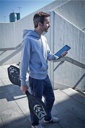Man with ipad and waveboard outdoors Stock Photo - Rights-Managed, Code: 853-06120411