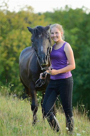 simsearch:853-06306120,k - Smiling girl with horse on meadow Stock Photo - Rights-Managed, Code: 853-06306118