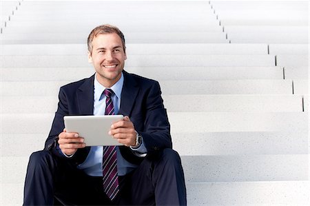 Businessman using tablet PC on stairs Stock Photo - Rights-Managed, Code: 853-06441715