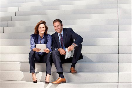 partnership concept - Businessman and businesswoman with tablet PC and newspaper on stairs Stock Photo - Rights-Managed, Code: 853-06441730