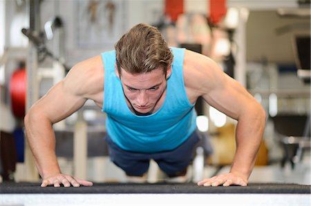 simsearch:853-03616708,k - Young man doing push-ups in fitness center Stock Photo - Rights-Managed, Code: 853-07241924