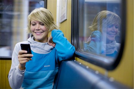 subway - Young woman using mobile phone in city train, front view Stock Photo - Rights-Managed, Code: 853-03458845