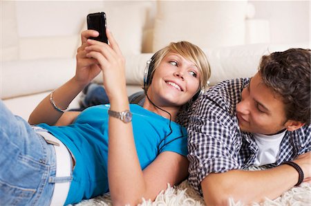 Teenager couple lying on carpet and listening to music, low-angle view Stock Photo - Rights-Managed, Code: 853-03458863