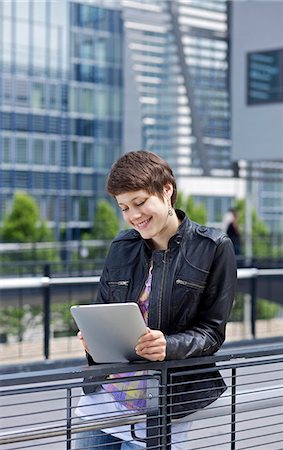 Young woman using iPad in front of an office building Stock Photo - Rights-Managed, Code: 853-03616871