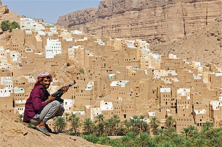 Yemen, Hadhramaut, Wadi Do'an, Ribat Ba-Ashan. A happy Yemeni man holds his AK-47. Stock Photo - Rights-Managed, Code: 862-05999722