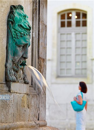 France, Provence, Arles, Place de la Republique, Woman walking past fountain  MR Stock Photo - Rights-Managed, Code: 862-06541477