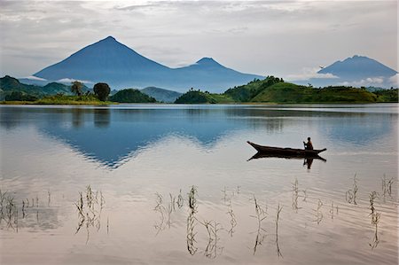 paddling - A woman paddles a dugout canoe across Lake Mutanda with its stunning backdrop of the Virunga Volcanoes, Uganda, Africa Stock Photo - Rights-Managed, Code: 862-06543263