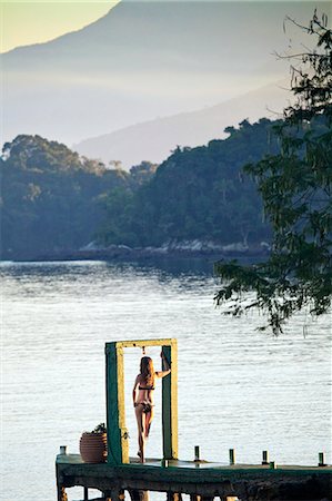 Angra dos Reis; Green Coast, Costa Verde, Ilha Grande, a model stands in an arch on the end of a pier at dawn Stock Photo - Rights-Managed, Code: 862-06675712