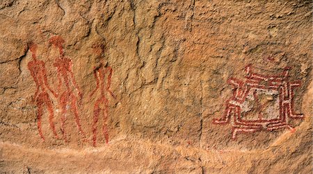 paint art of africa - Chad, Gaora Hallagana, Ennedi, Sahara. An ancient rock painting of three human figures, two holding lances, and a bichrome geometric design. Stock Photo - Rights-Managed, Code: 862-06676403
