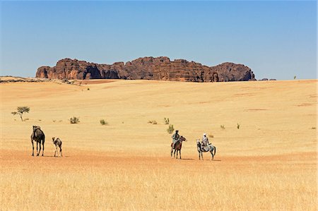 sahara camel - Chad, Deli, Ennedi, Sahara. Toubou horsemen ride their horses across the arid plains near Deli. Stock Photo - Rights-Managed, Code: 862-06676475