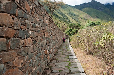 simsearch:862-06677365,k - South America, Peru, Cusco, Nusta Hispana. Terraces, a hiker walks next to a long Inca wall and causeway at Choquequirao, built by Tupac Inca Yupanqui and Huayna Capac and situated above the Apurimac valley in the mountains of the Salkantay range Stock Photo - Rights-Managed, Code: 862-06677416