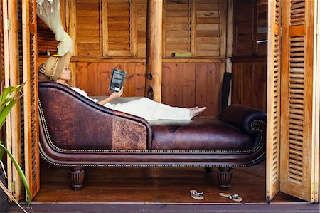 Dominica, Portsmouth, Tanetane. A young lady reads whilst laying on a Chaise Lounge at Manicou River Resort.(MR). Stock Photo - Rights-Managed, Code: 862-06825265