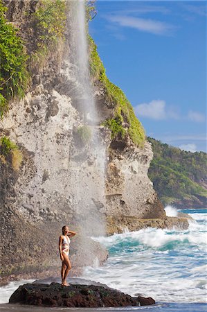 Dominica, Riviere Cyrique. A young woman stands under the waterfall at Wavine Cyrique. (MR). Foto de stock - Con derechos protegidos, Código: 862-06825295