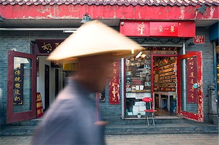 simsearch:862-05997261,k - Beijing, China. Old man with conical hat passing in front of a shop in a hutong of Beijing Stock Photo - Rights-Managed, Code: 862-07909450