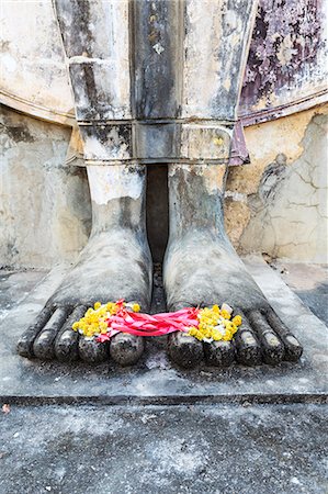 Thailand, Sukhothai Historical Park. Detail of Buddha feet with floreal offering Stock Photo - Rights-Managed, Code: 862-07910828
