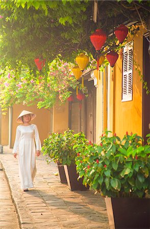 Woman wearing Ao Dai dress walking along street, Hoi An (UNESCO World Heritage Site), Quang Ham, Vietnam (MR) Stock Photo - Rights-Managed, Code: 862-07911091