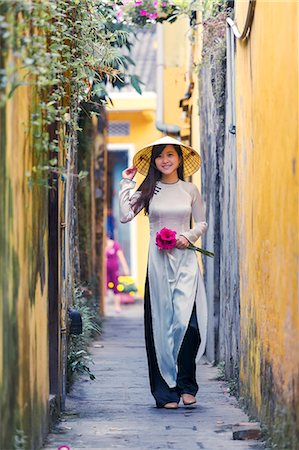 Vietnam, Hoi An. Young vietnamese girl with Ao Dai dress walking in a alley (MR) Stock Photo - Rights-Managed, Code: 862-07911117