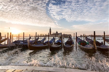 simsearch:862-07690164,k - Italy, Veneto, Venice. Row of gondolas moored with high tide waves splashing Stock Photo - Rights-Managed, Code: 862-08090432