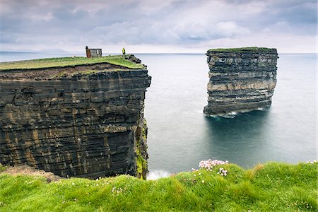 Downpatrick Head, Ballycastle, County Mayo, Donegal, Connacht region, Ireland, Europe. A man watching the sea stack from the top of the cliff. Stock Photo - Rights-Managed, Code: 862-08699398