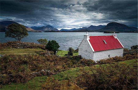 Scotland, Wester Ross. A brightly coloured cottage beside Loch Shieldaig on a gloomy day. Stock Photo - Rights-Managed, Code: 862-08699969