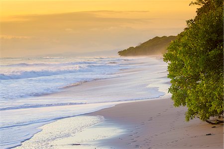 paradise sunset beach - Playa Santa Teresa at sunset, Mal Pais, Costa Rica. Young girl looking at the ocean on the beach. Stock Photo - Rights-Managed, Code: 862-08718530