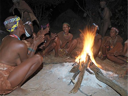 A small band of Bushmen,or San,sing round their campfire. These NS hunter gatherers live in the Xai Xai Hills close to the Namibian border. Their traditional way of life is fast disappearing. Stock Photo - Rights-Managed, Code: 862-03289586