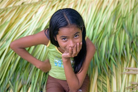 Young village girl sits on bed of newly cut crops in Jamaraqua Village watching the world go by. Jamaraqua Community,Amazon Region,Brazil Stock Photo - Rights-Managed, Code: 862-03289717