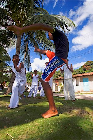 salvador - Brazil,Bahia,Boipeba Island. Young men and boys train at Capoeira the ritualistic slave dance martial dance of Brazil where staged movements hide fighting stances,defensive postures and attacking jabs Stock Photo - Rights-Managed, Code: 862-03289786