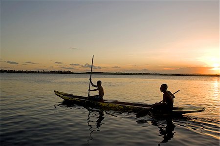 simsearch:862-07495921,k - Brazil,Bahia,Barra de Serinhaem. Fishermen returning to shore at sunset in thier dug out canoe. Stock Photo - Rights-Managed, Code: 862-03289792