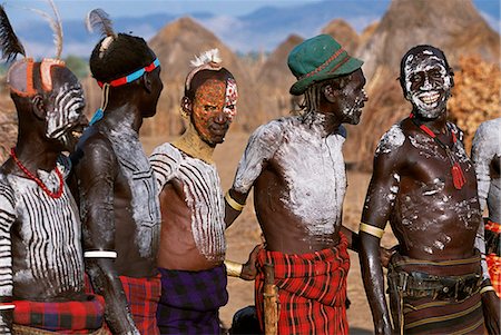 Lors d'une danse dans le peuplement de hommes de village de Duss Karo en attente à la danse. Une petite tribu Omotic associés à la Hamar, le Karo vivant le long des rives du fleuve Omo en Éthiopie du Sud-Ouest. Ils sont réputés pour leur art de corps élaborés à l'aide de craie blanche, la pierre concassée et autres pigments naturels. Photographie de stock - Rights-Managed, Code: 862-03354041