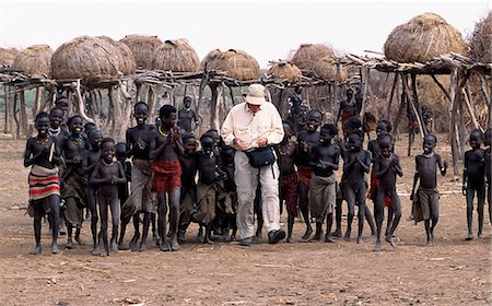 simsearch:862-03353978,k - A tourist accompanied by a retinue of children in a Dassanech settlement along the lower Omo River. Much the largest of the tribes in the Omo Valley numbering around 50,000,the Dassanech (also known as the Galeb,Changila or Merille) and Nilotic pastoralists and agriculturalists. Stock Photo - Rights-Managed, Code: 862-03354069