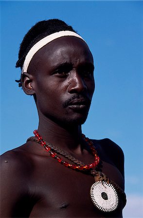 A Dassanech man shows off his distinctive hairdo and ornamentation. Much the largest of the tribes in the Omo Valley numbering around 50,000,the Dassanech (also known as the Galeb,Changila or Merille) are Nilotic pastoralists and agriculturalists. Stock Photo - Rights-Managed, Code: 862-03354073