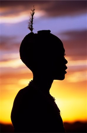 A young Dassanech boy silhouetted against the evening sky at his settlement alongside the Omo River. Much the largest of the tribes in the Omo Valley numbering around 50,000,the Dassanech (also known as the Galeb,Changila or Merille) are Nilotic pastoralists and agriculturalists. Stock Photo - Rights-Managed, Code: 862-03354085