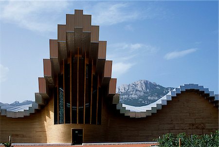 The striking architecture of Ysios winery,designed by world renowned architect Santiago Calatrava,mirrors the undulations of the limestone mountains of the Sierra de Cantabria rising behind Stock Photo - Rights-Managed, Code: 862-03354361