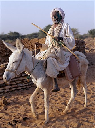 sudan - As the sun goes down after a blistering day,an old man rides home on his donkey. Stock Photo - Rights-Managed, Code: 862-03354567