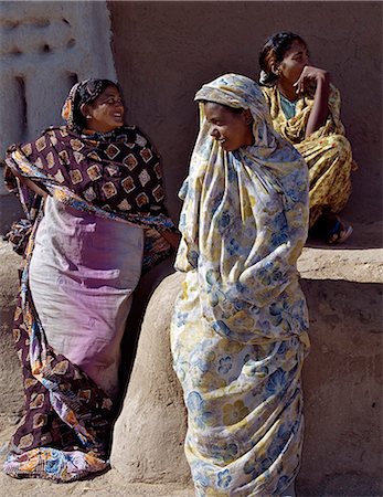 sudan - Three women relax outside a house at Qubbat Selim. This village,situated close to the River Nile in Northern Sudan,still retains much of its traditional architecture,plasterwork and decoration. Stock Photo - Rights-Managed, Code: 862-03354613