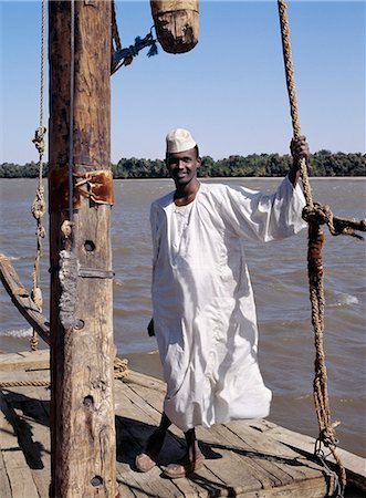 sudan - A Nubian boatman on his felucca,a wooden sailing boat that plies the waters of the River Nile in Egypt and The Sudan. Stock Photo - Rights-Managed, Code: 862-03354628